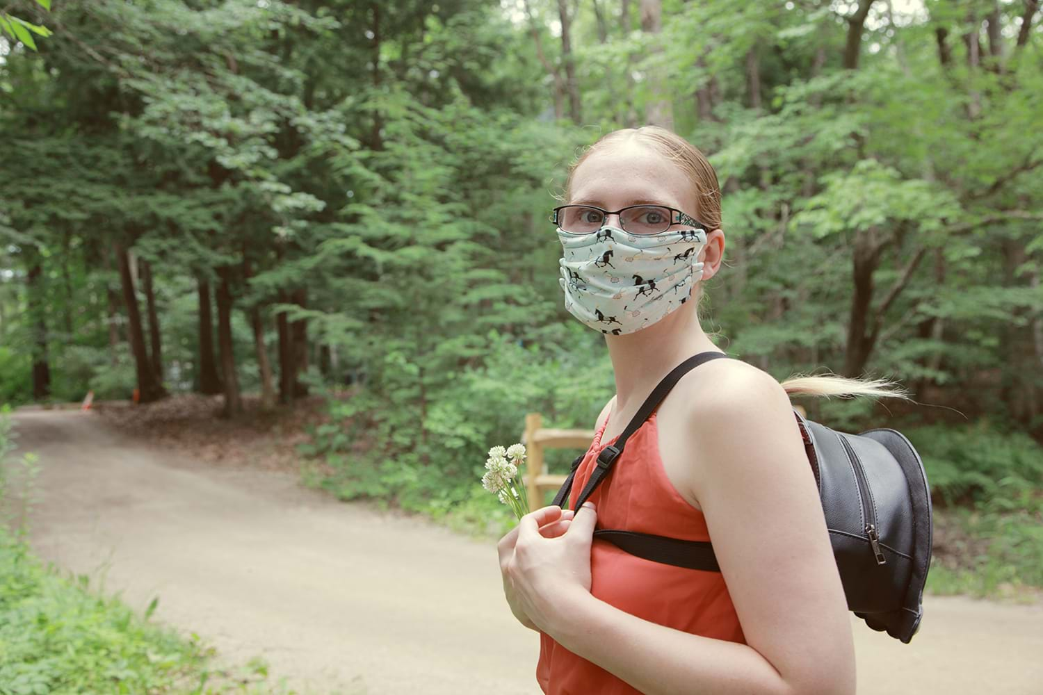 Woman in mask walking through woods