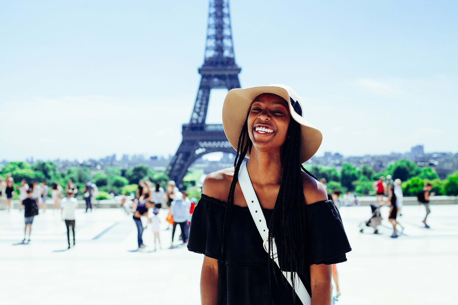 Woman smiling standing in front of Eiffel Tower