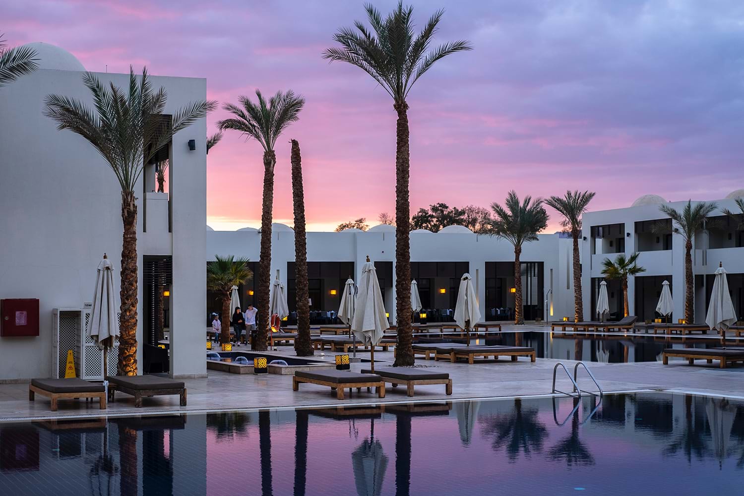 Hotel pool courtyard with violet sunset sky