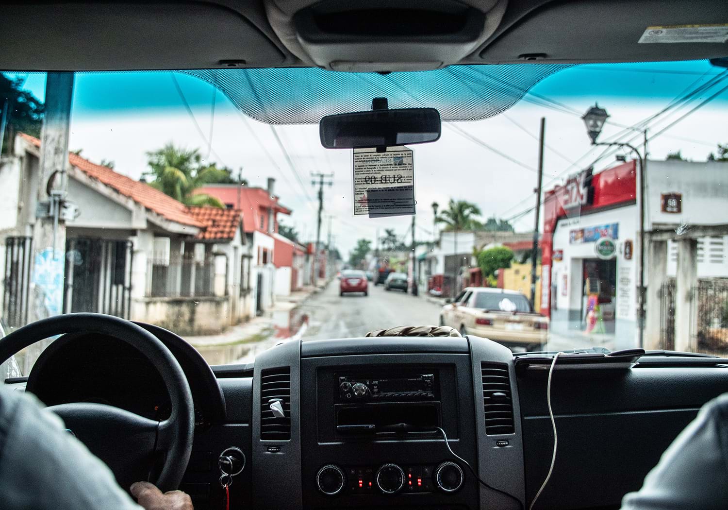 View through car windshield as it goes down street