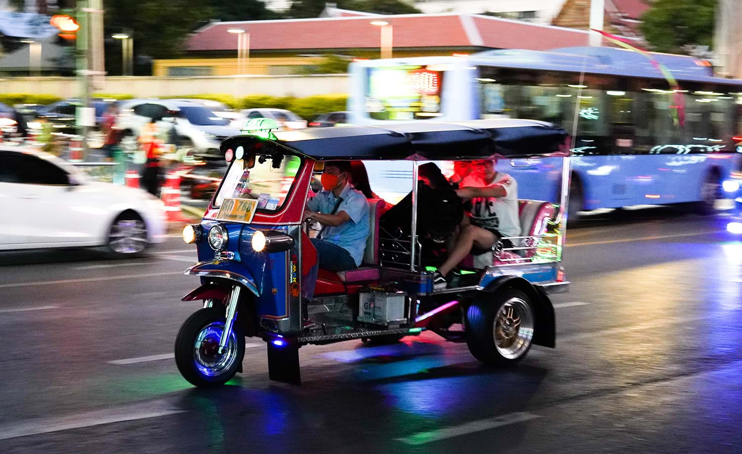 Three-wheeled taxi cruising down city street