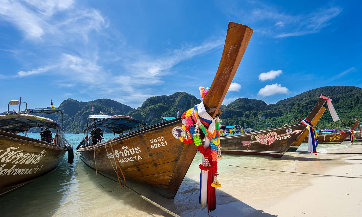 Wooden boats resting on edge of beach