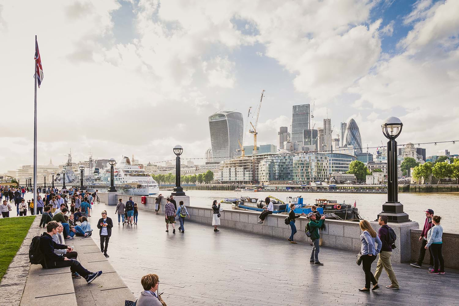 Crowds of people across river from London skyline