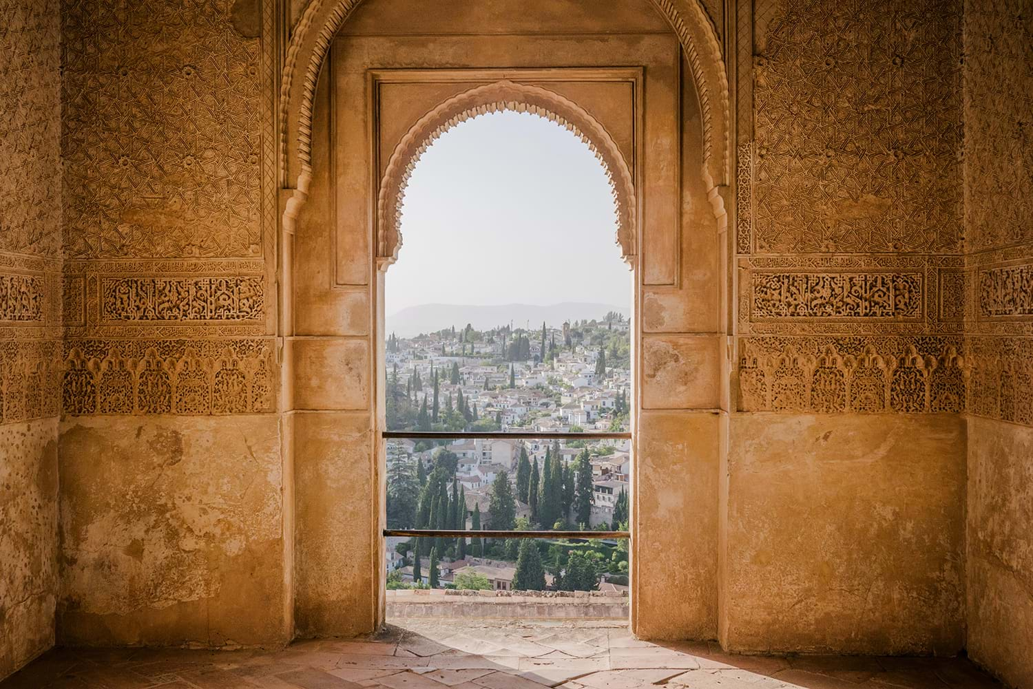 View through arched opening in building looking out at town