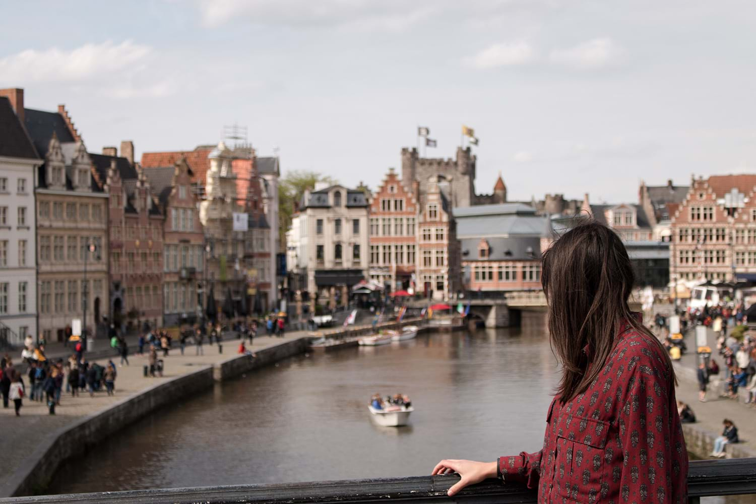 Woman on bridge over river through city