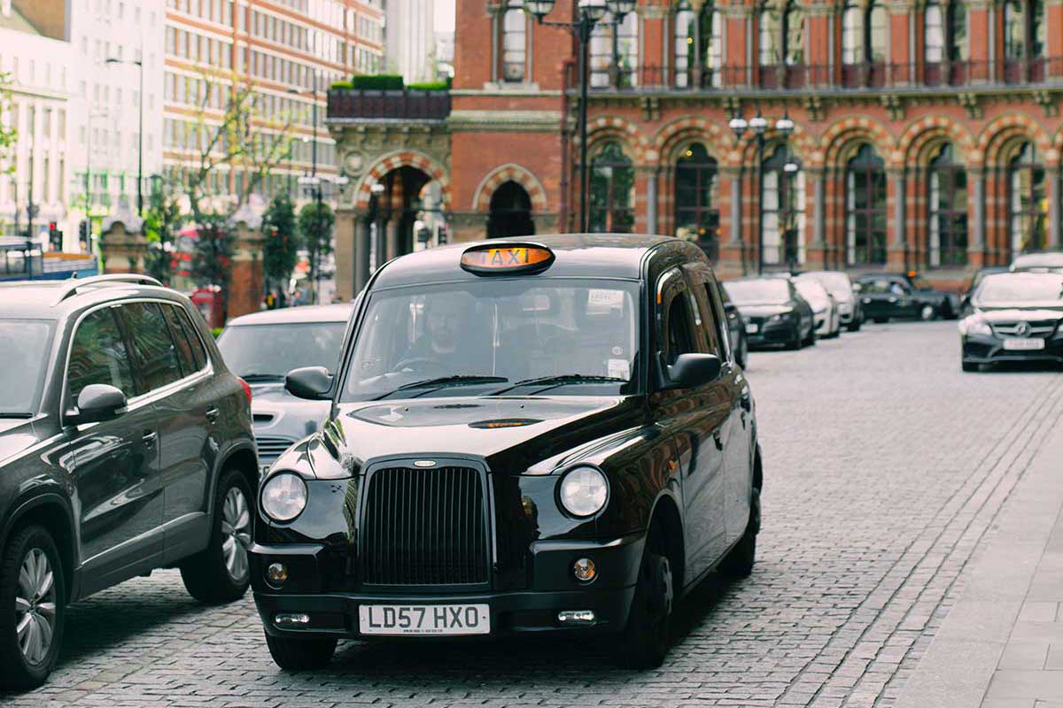 Black taxi on brick road