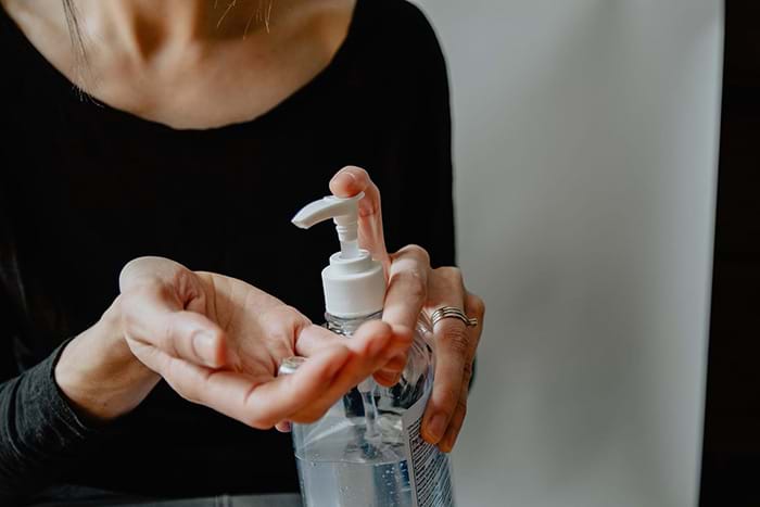 Woman putting on hand sanitizer