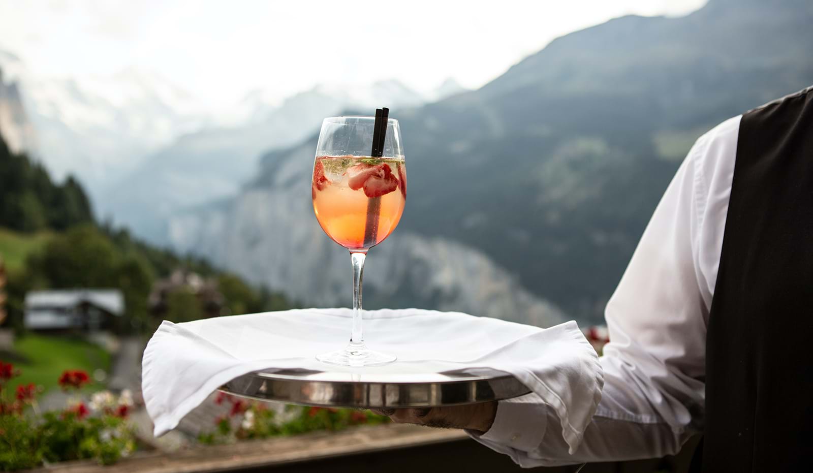 Server carrying cocktail on platter