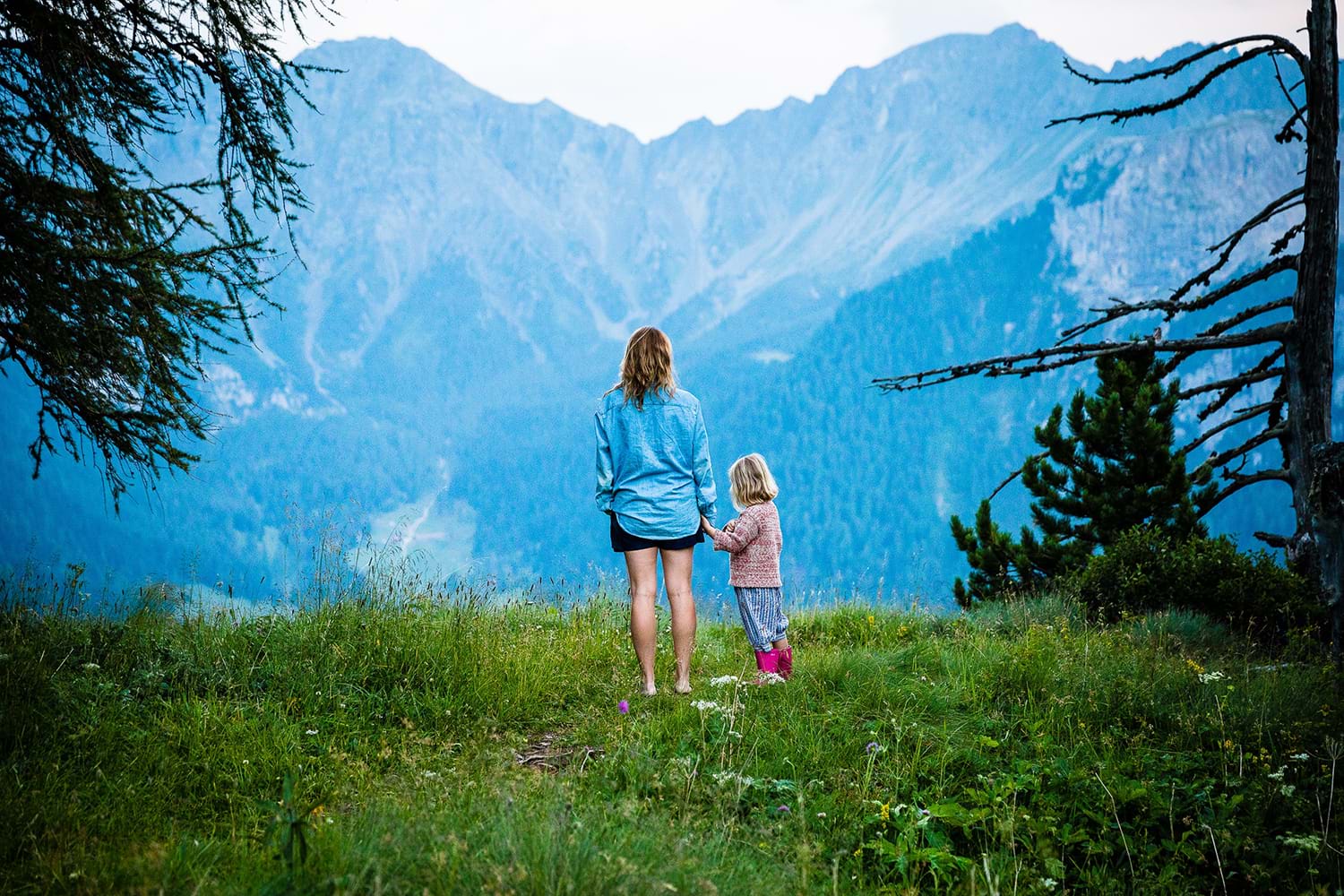 Woman standing with child looking at view of mountains