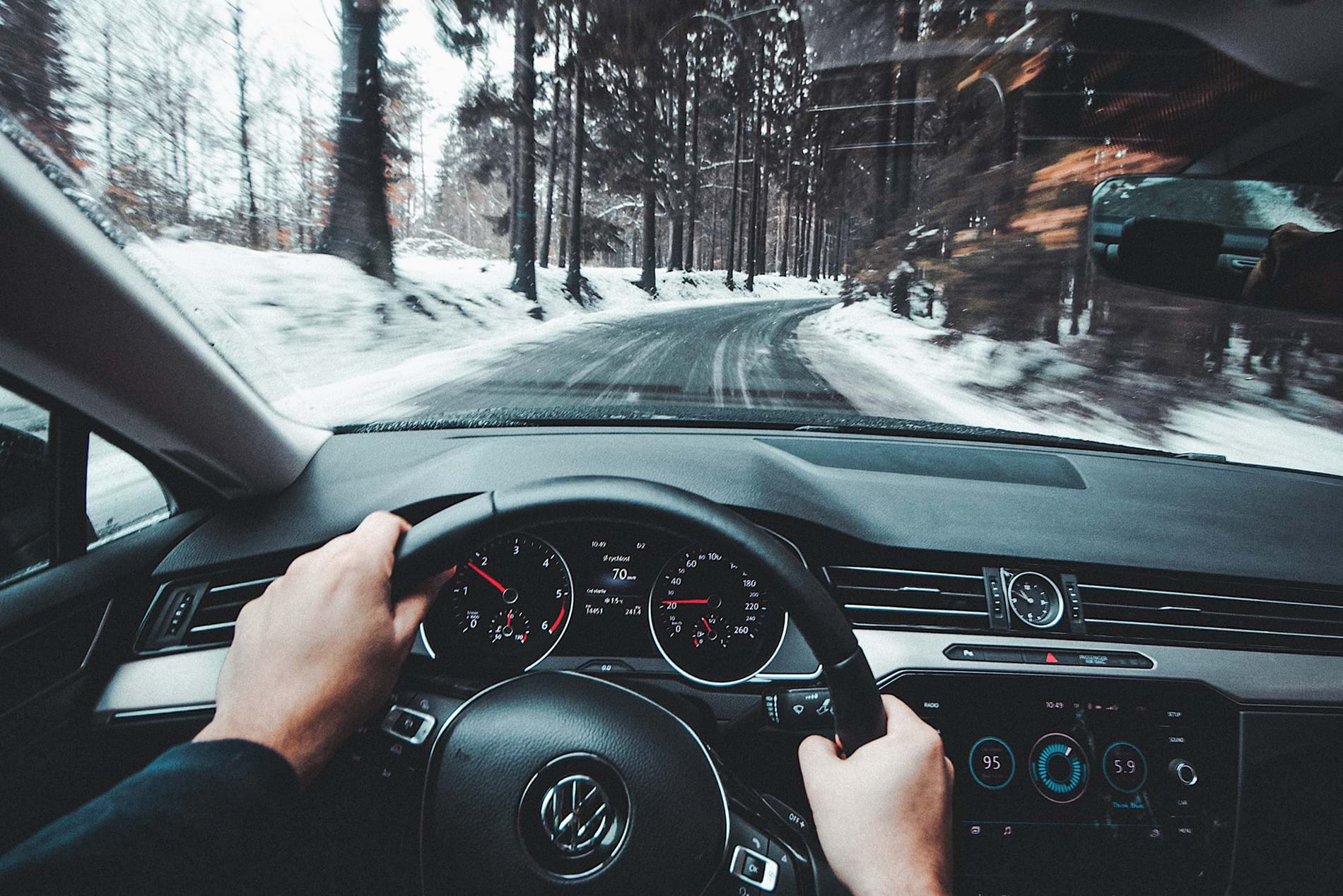 Driving car on road through snowy forest