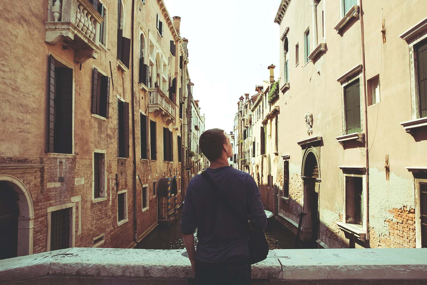 Person on bridge over Venice canal