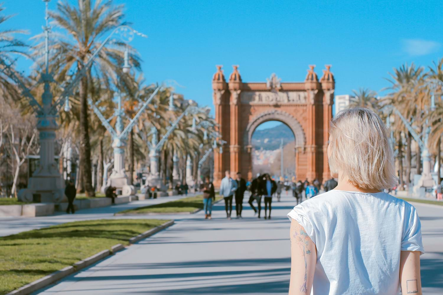 Woman walking toward copper colored ornate arch