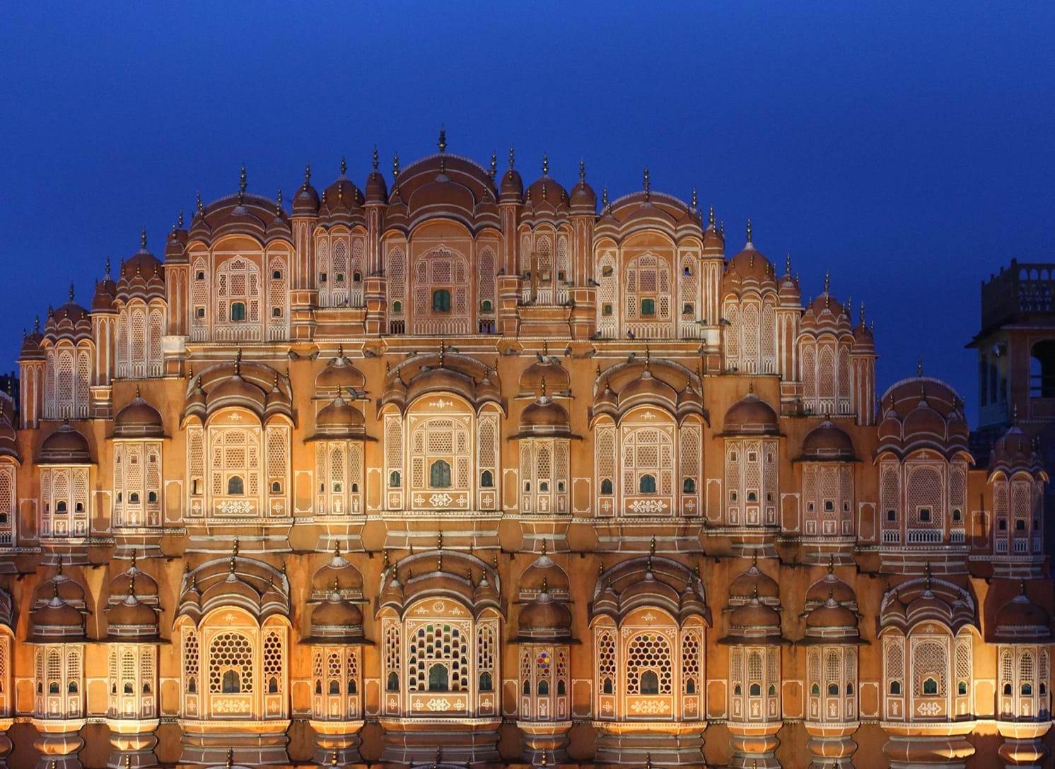 Orange-brown decorative building illuminated at night