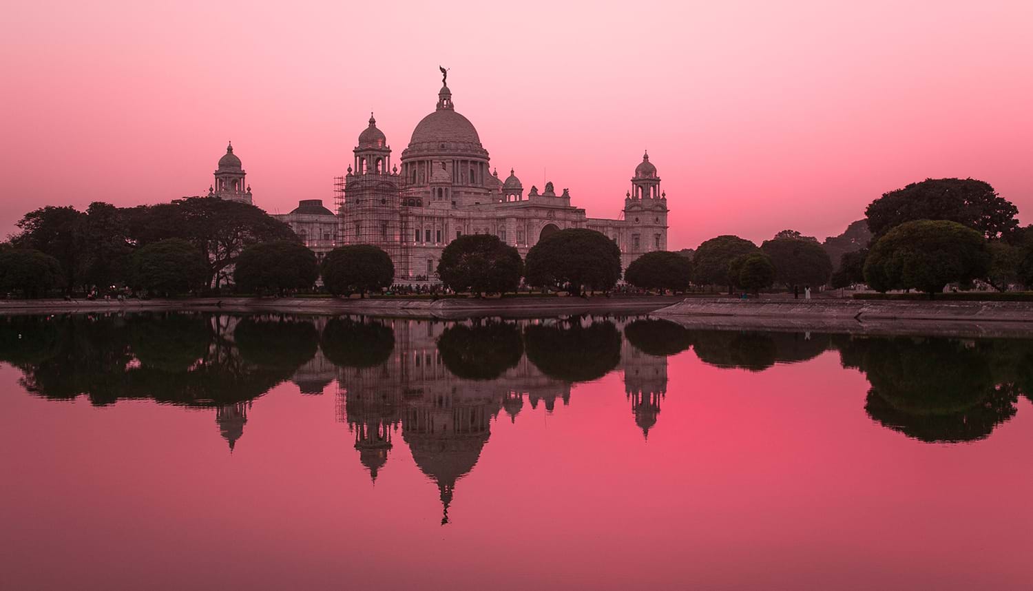 Domed building and pink sky reflected off water