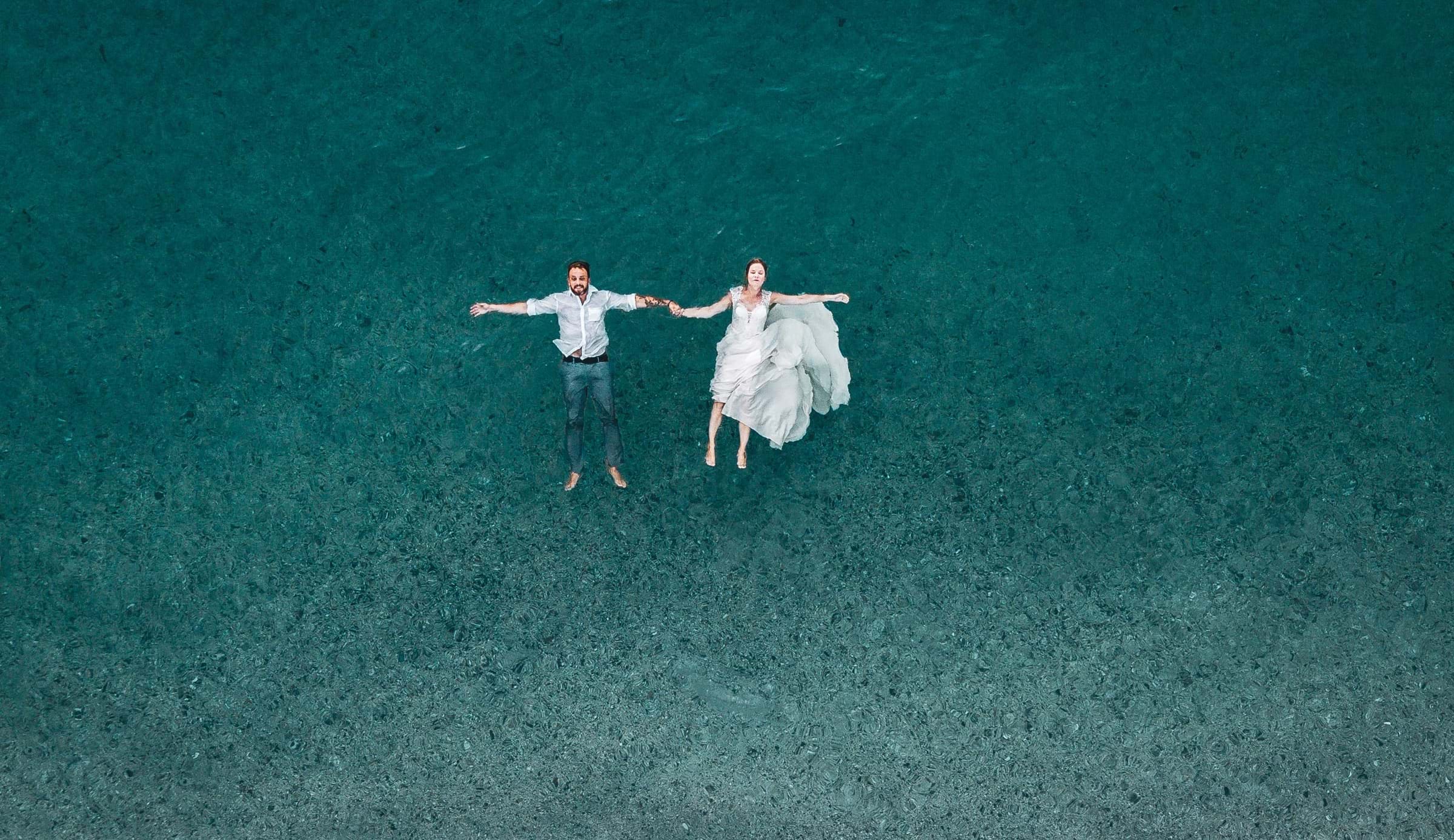Couple fully dressed floating in water