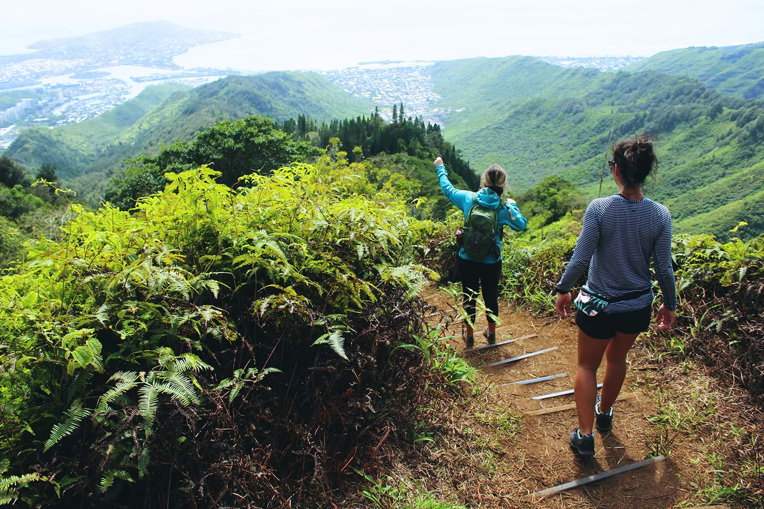 Two women hiking down mountain path