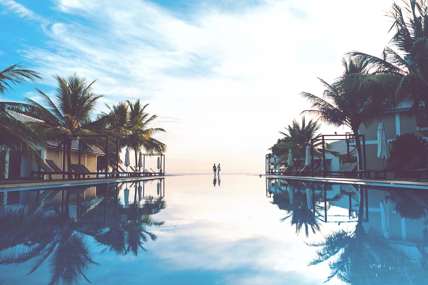 Calm resort pool reflecting the sky