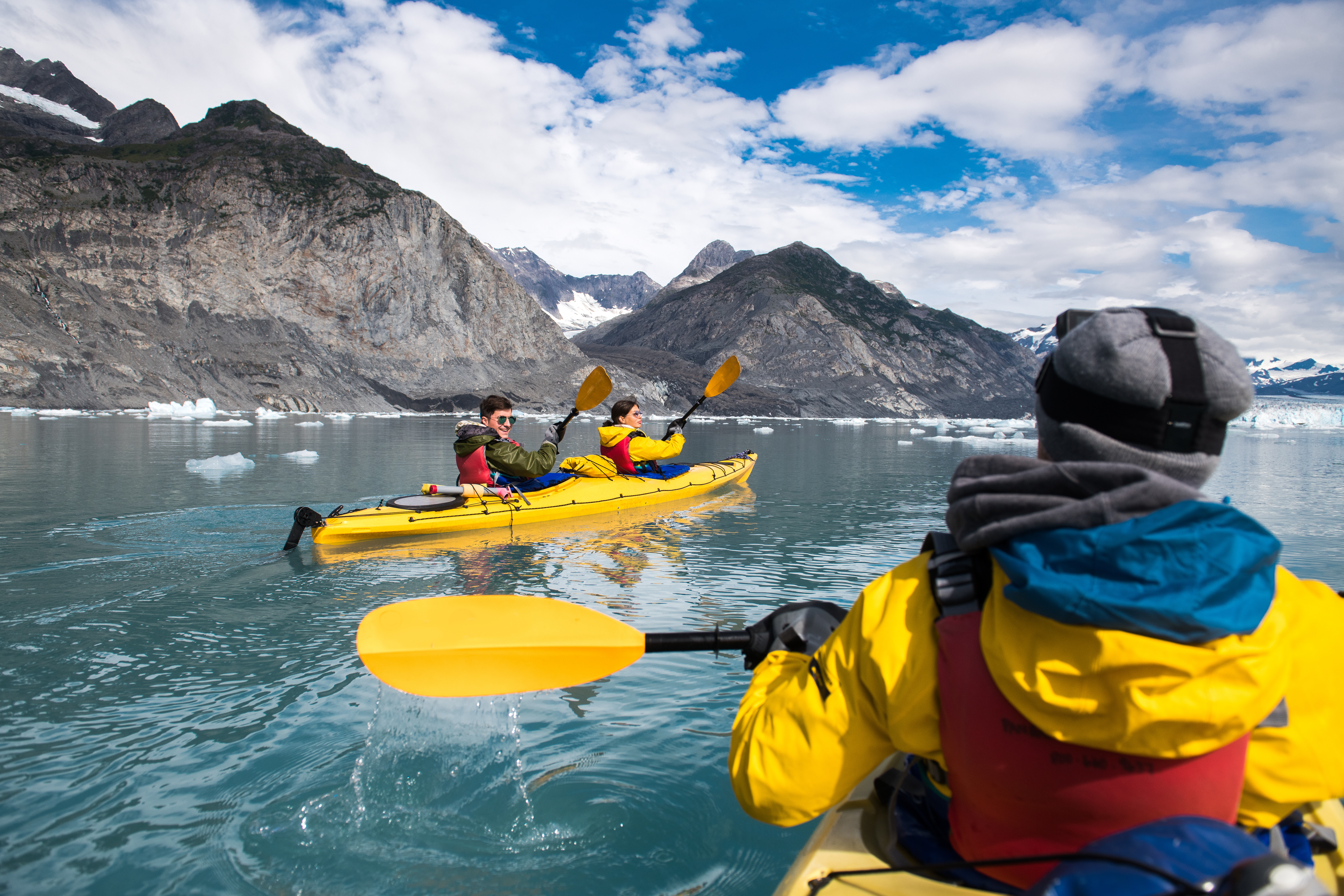 friends kayaking near glacier in Alaska