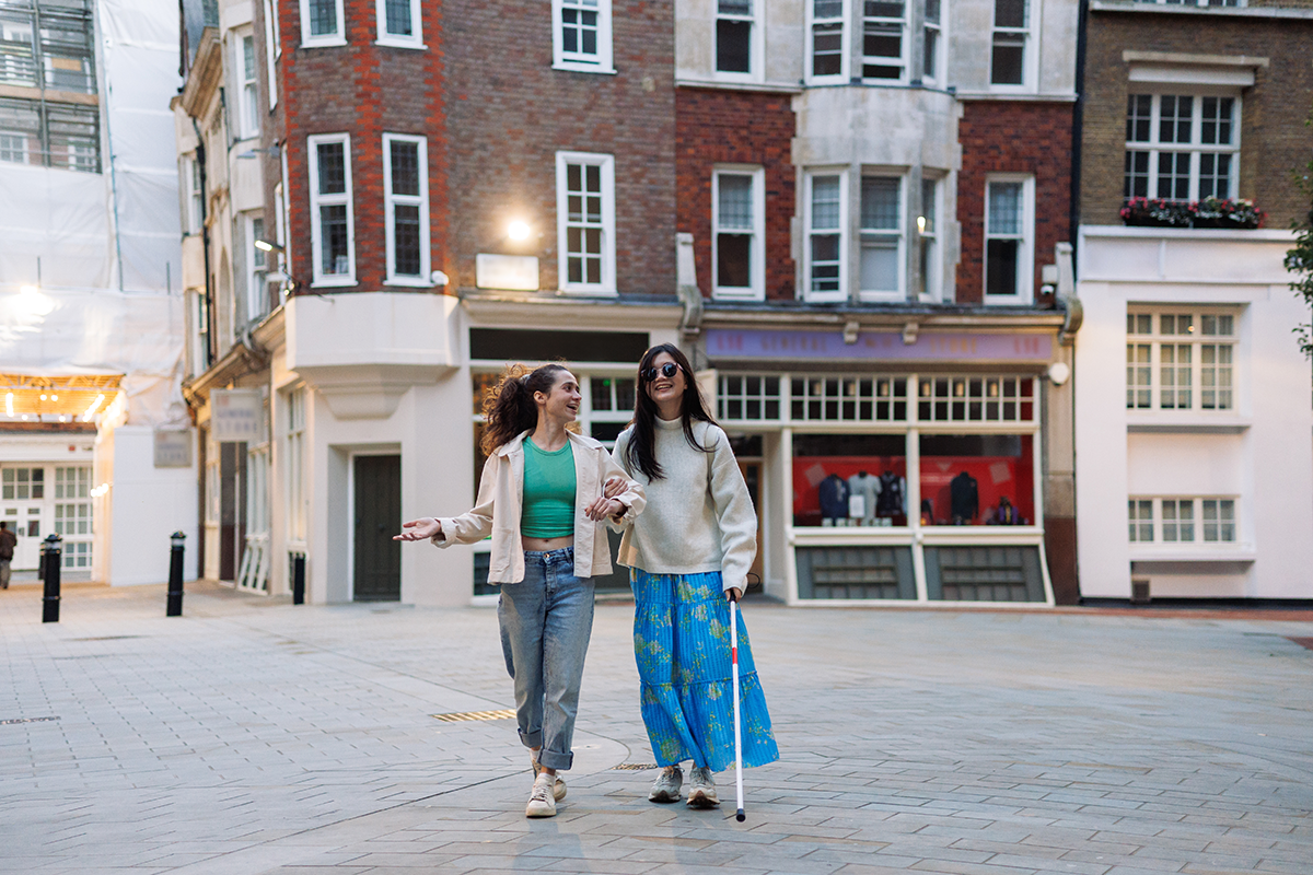 Blind woman and her friend walking in city