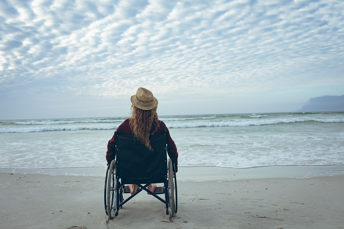Woman in wheelchair on beach