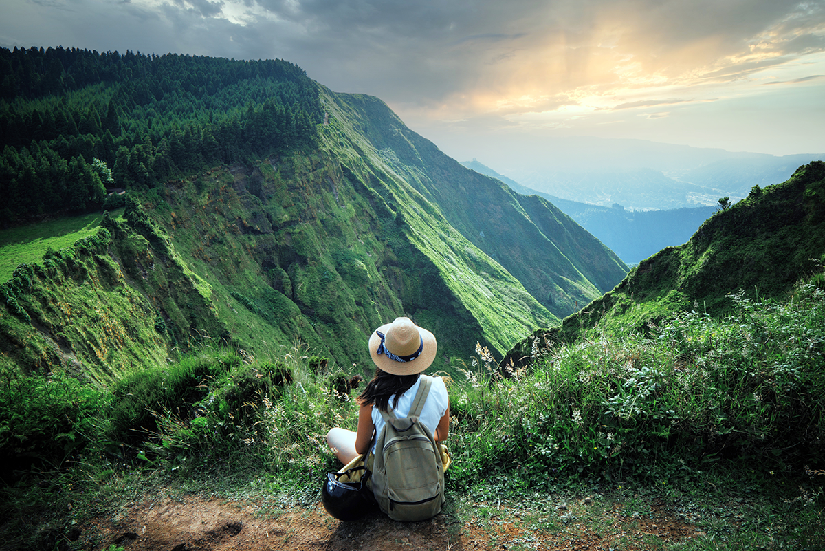Woman enjoying view of beautiful forest-covered mountains