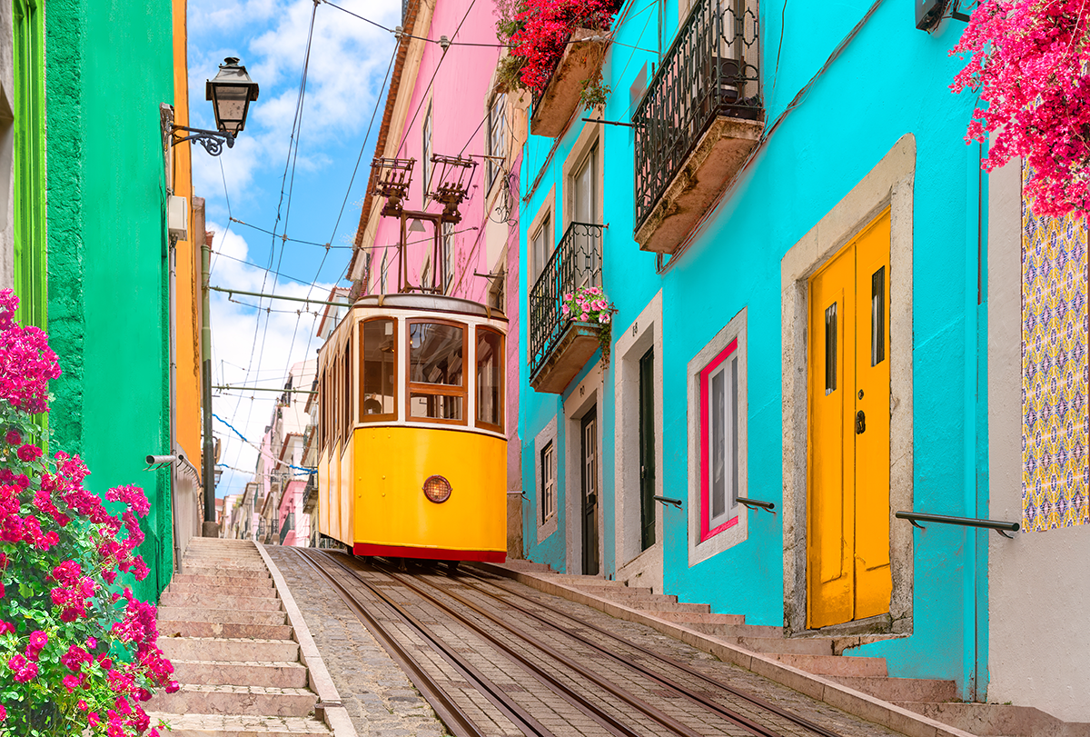 Yellow tram descending street with colorful buildings in Lisbon, Portugal