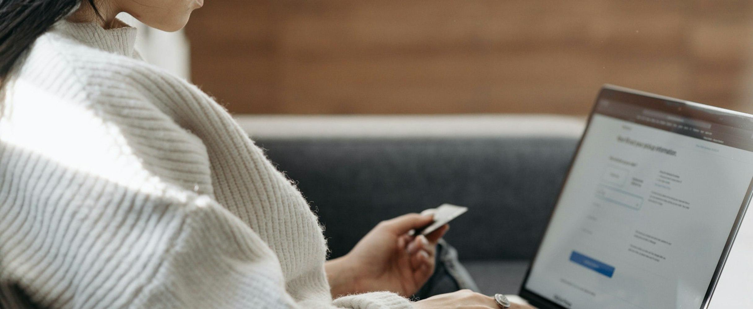 Woman using a laptop and credit card to pay for photography services online