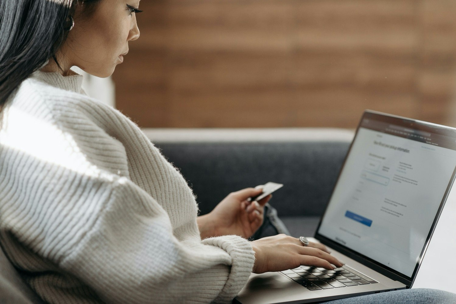 Woman using a laptop and credit card to pay for photography services online