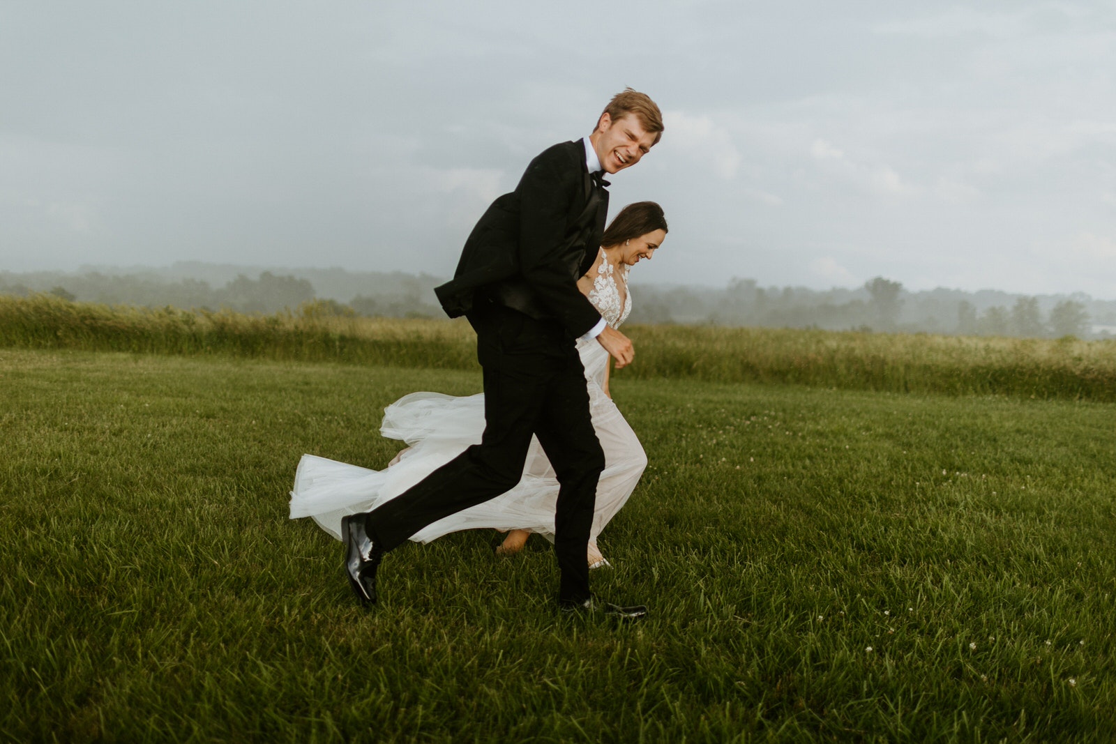 A bride and groom captured running across a field, using the camera’s burst shooting mode.