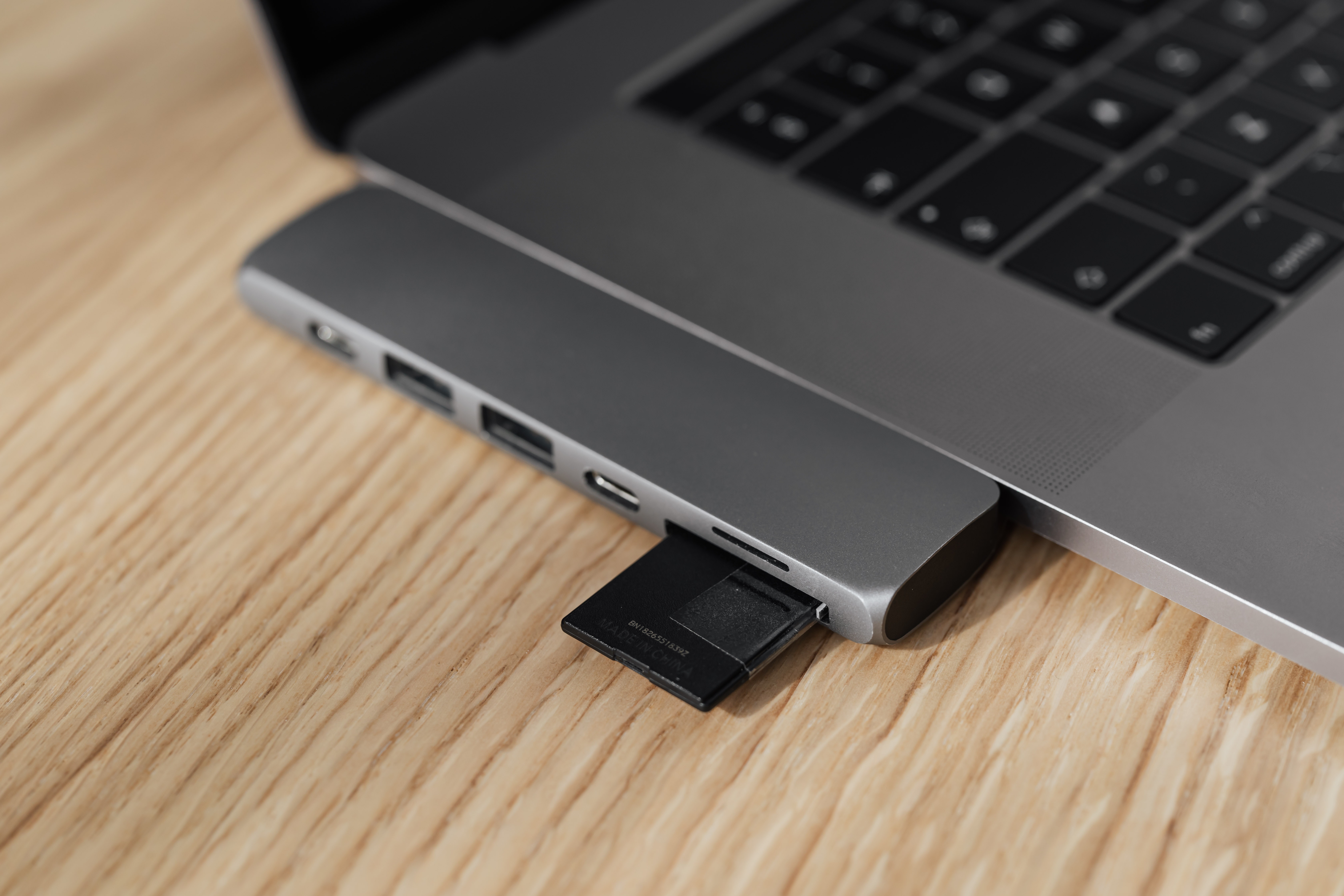 A photographer’s laptop with an USB memory card reader and an SD card.