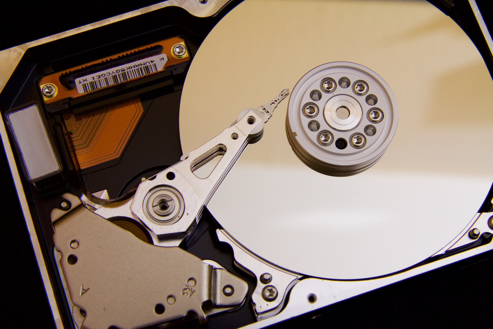 An inside look of a hard disk drive, featuring a spindle and circular disks that hold data.