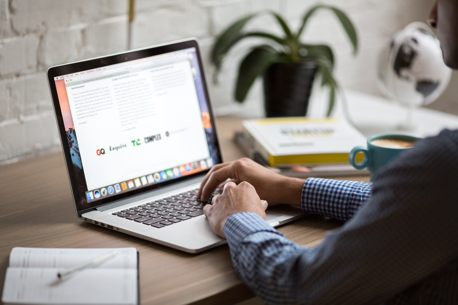 A male photographer using a laptop at home to design and optimize his website.