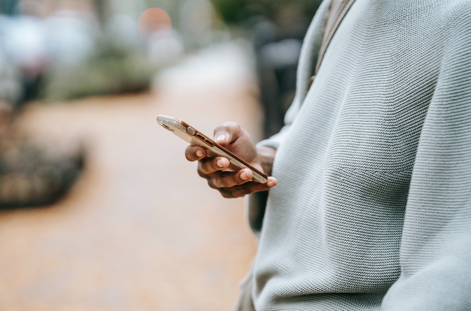 A woman using a gold-colored smartphone to subscribe to a photographer’s newsletter.