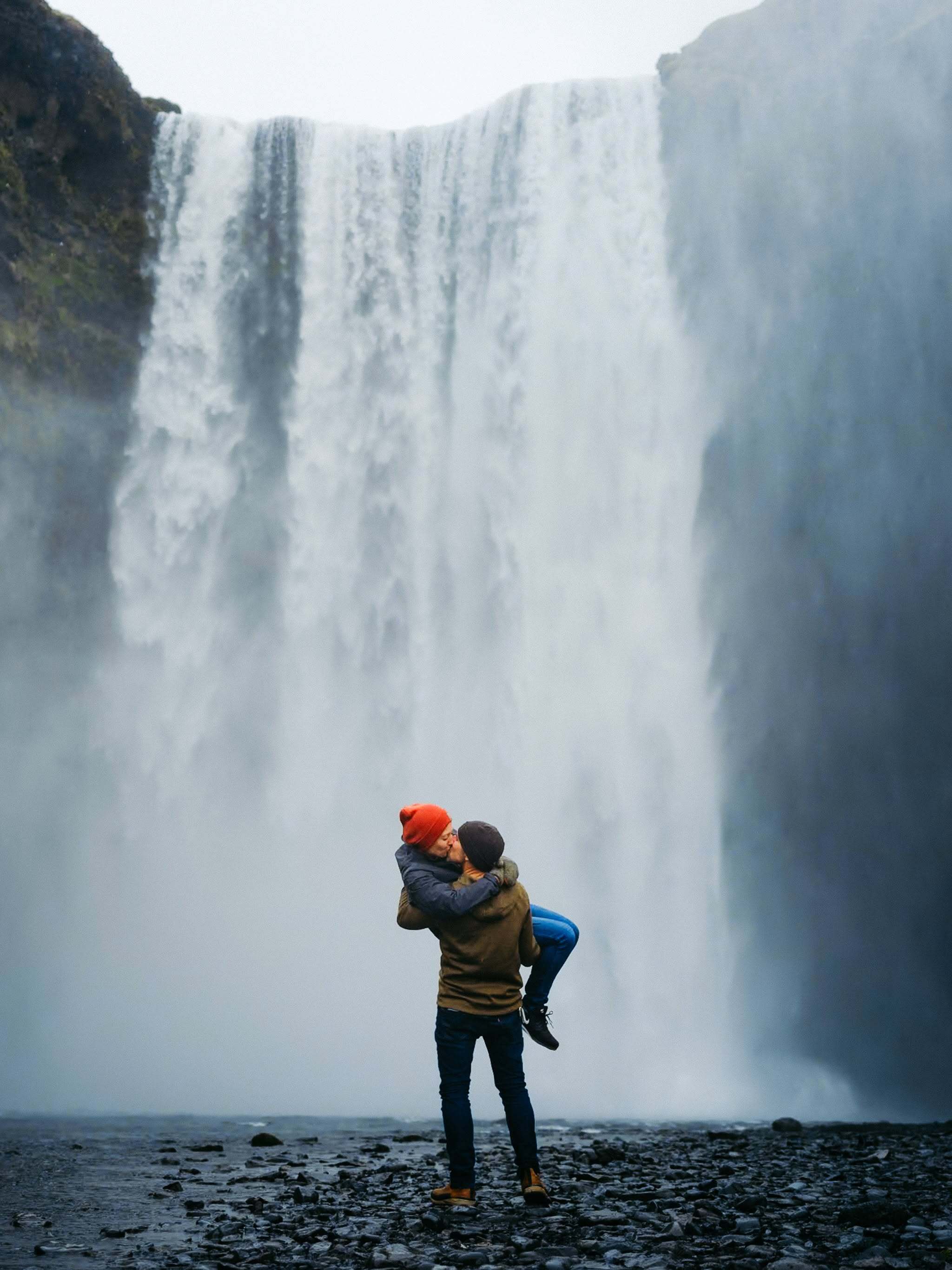 Bride and groom sharing a kiss in front of a waterfall during their wedding day, captured by Ely and edited using Narrative photo editing software.