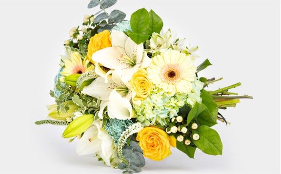 Beautiful bouquet of flowers with white lilies, yellow roses, and various greenery on a white background, perfect for weddings or special occasions.