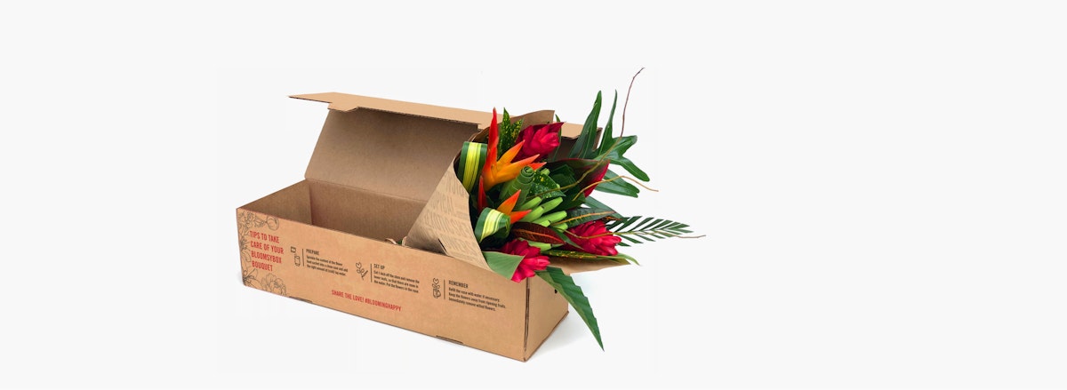 Vibrant floral arrangement featuring tropical flowers, beautifully packaged in a sturdy box.