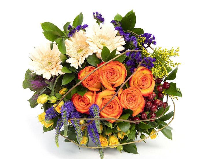 Vibrant bouquet featuring orange roses, white gerberas, purple flowers, and greenery, artistically arranged against a white background.