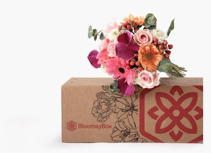Vibrant bouquet of fresh flowers with roses and lilies emerging from a BloomysBox, set against a clean white background, highlighting the floral arrangement and packaging.