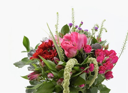 Vibrant floral arrangement with a mix of red roses, pink peonies, and green foliage on a white background, perfect for weddings or special occasions.