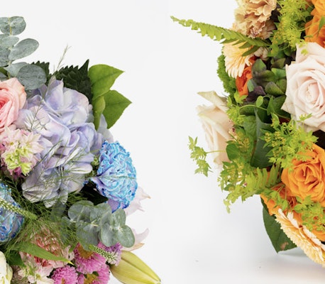 Two vibrant bouquets featuring a mix of roses, hydrangeas, and various greenery on a white background, showcasing a rich palette of blue, pink, orange, and green hues.