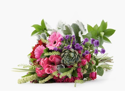 Vibrant floral arrangement featuring a variety of flowers including roses, carnations, and greenery against a white background, perfect for special occasions.
