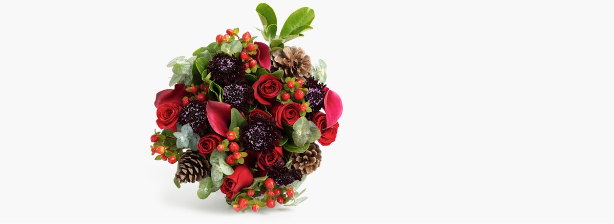 Vibrant floral bouquet featuring red roses, pinecones, and seasonal berries for festive occasions.