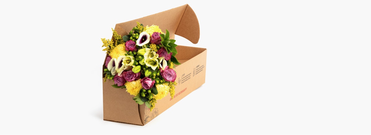 Vibrant floral arrangement featuring yellow, purple, and white blooms in eco-friendly packaging.