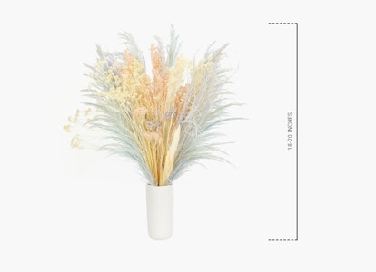 An elegant array of artificial pampas grass in soft hues displayed in a white vase against a clean white background, alongside a measurement scale.