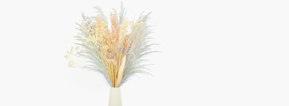 Elegant dried floral arrangement featuring soft pastel shades in a minimalist vase.
