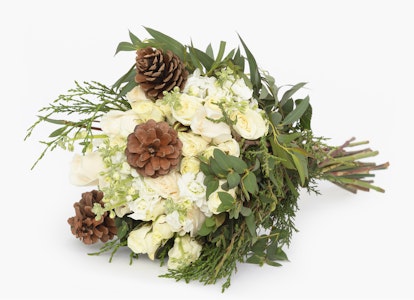 Elegant floral arrangement with white blooms and greenery accompanied by pine cones on a clean white background, perfect for weddings or festive occasions.