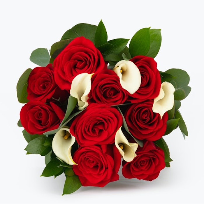 Elegant bouquet of vibrant red roses and delicate white calla lilies arranged together on a clean white background, perfect for romantic occasions or as a gift.