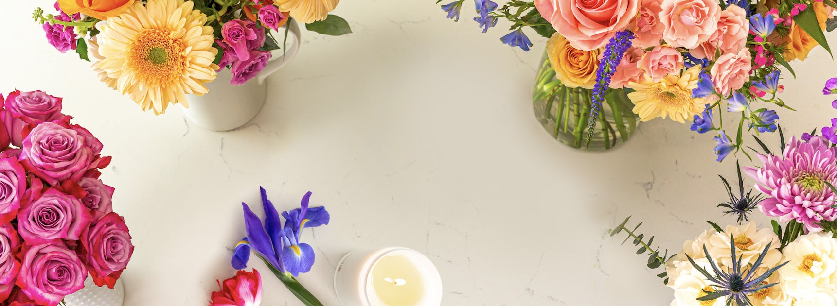 Vibrant floral arrangement featuring roses, gerbera daisies, and colorful blooms in stylish vases.