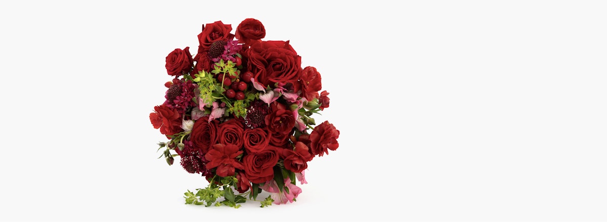 Vibrant bouquet of deep red roses and rich green foliage in an elegant arrangement.