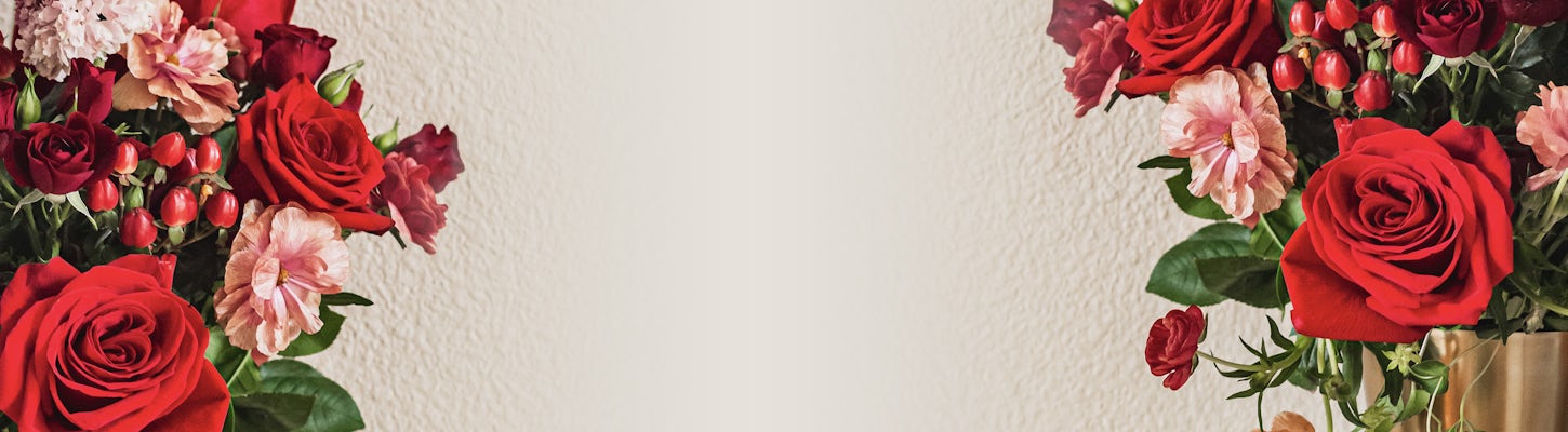 A vibrant floral arrangement featuring red roses and pink blossoms, ideal for celebrations.